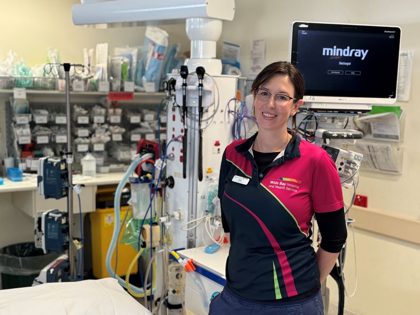 A woman is situated in a hospital room, accompanied by a medical machine, conveying a sense of medical attention and support.