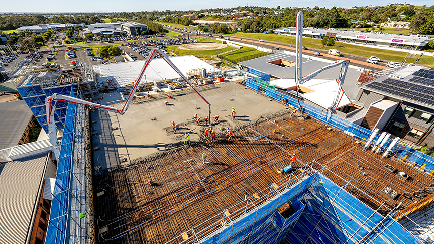 An image of concrete being poured onto a roof to support a future helipad