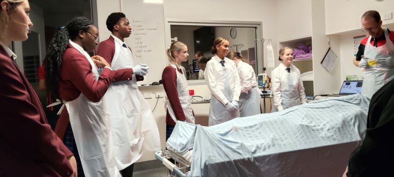 Group of high school students in a hospital room learning about health care