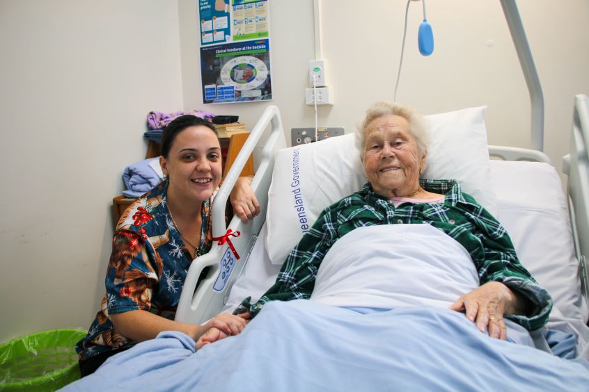 Nurse with patient in hospital bed
