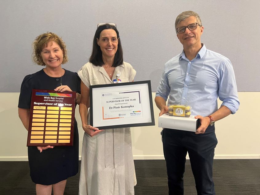 Doctor with two healthcare workers receiving his award