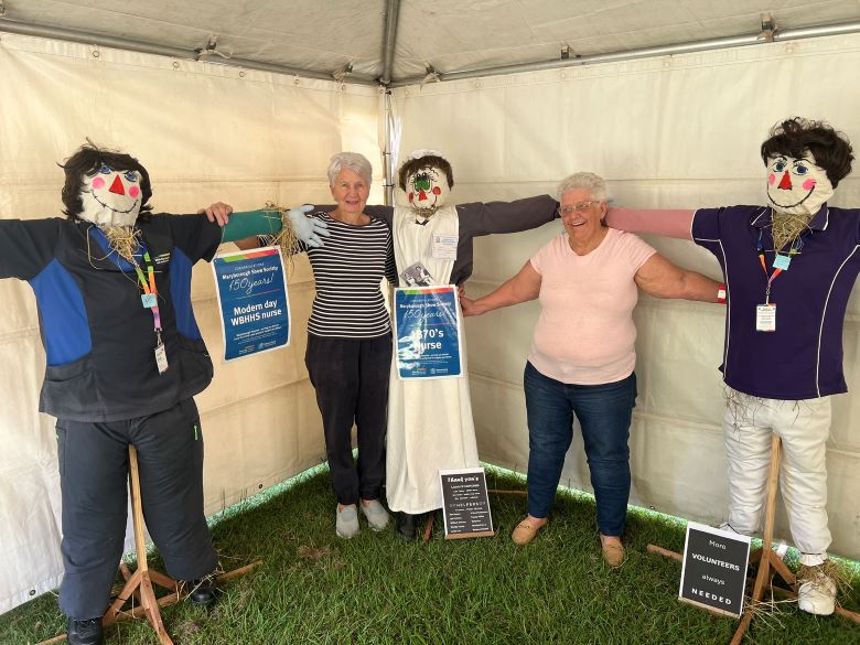 Women standing with scarecrows dressed in period nursing uniforms
