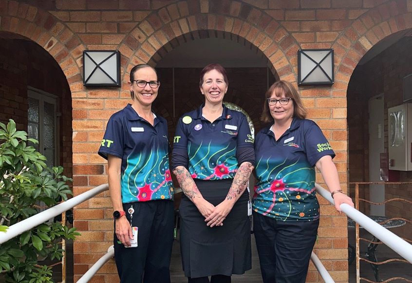 Three healthcare workers standing outside building